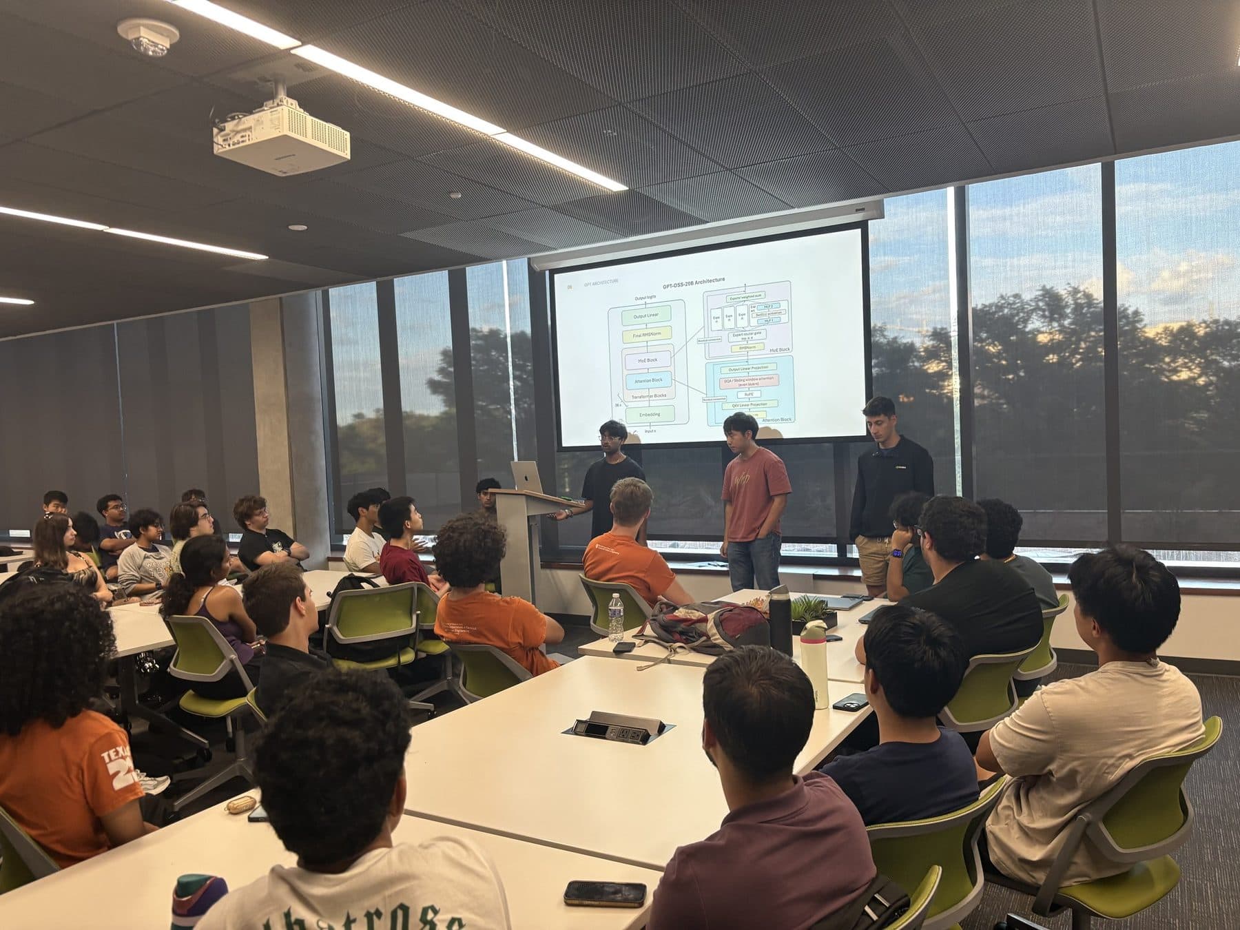 A speaker presenting a block diagram to a full classroom at a general meeting
